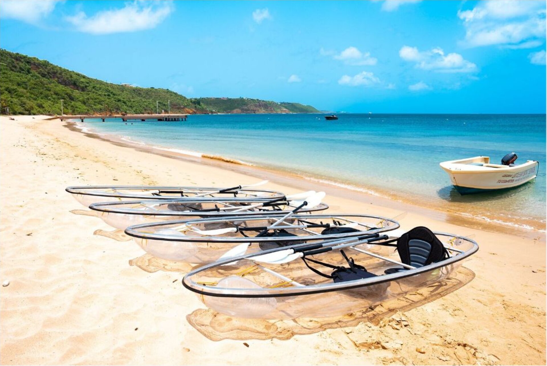 Clear turquoise water, a small boat and transparent kayaks on Crocus Bay, Anguilla